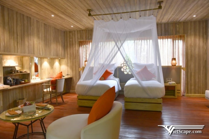Phòng Jungle Rock Villa 65m2 gồm 1 giường đôi lớn, 1 giường sofa và sở hữu không gian nguyễn gỗ ấm cúng